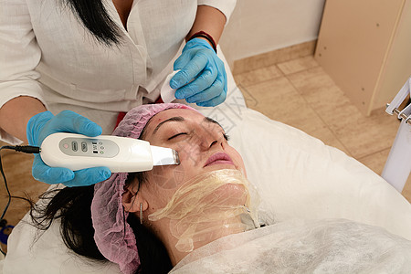 在美容院的年轻女子 做超声波剥皮 和面部清洗程序按摩频率沙龙美容药品治疗福利电疗按摩器硬件图片