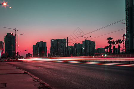 日落时长期暴露的城市景场拍摄 - 红色是多米纳图片