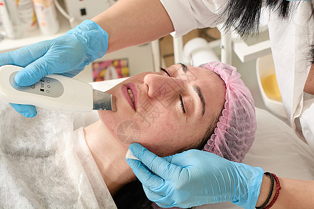在美容院的年轻女子 做超声波剥皮和面部清洗程序福利护理皮肤真空医生收音机诊所女士治疗按摩器图片