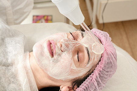 在美容院的年轻女子 确实恢复了活力 将程序Darsonval在脸上医生硬件诊所女性治疗按摩器皮肤科药品皱纹皮肤图片