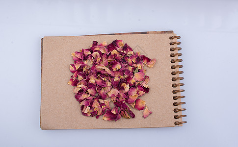玫瑰馒头螺旋笔记本上的干玫瑰花瓣办公室宏观备忘录叶子草本植物文档植物笔记纸治愈床单背景