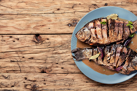 木制背景的烤鱼桌子盘子午餐鲈鱼柠檬油炸炙烤饮食海洋烧烤图片