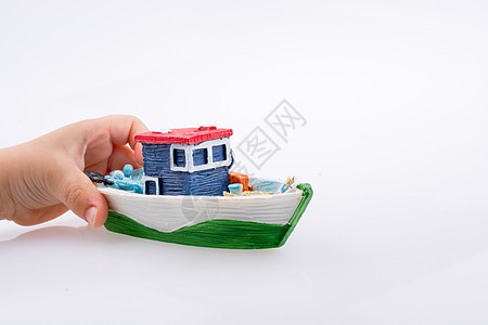 手头鲜多彩的模样小船玩具血管游艇旅行孩子想像力运输蓝色白色帆船图片