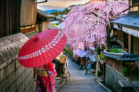 身穿日本传统和服的女人在日本京都的春日山区走过历史之旅街道浴衣旅行寺庙神社女孩樱花城市地标文化图片