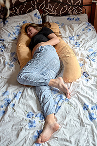 年轻孕妇 怀孕的美容妇女睡在床上的产期枕头上妈妈身体产妇女士家庭婴儿黑发肚子妇科腹部图片