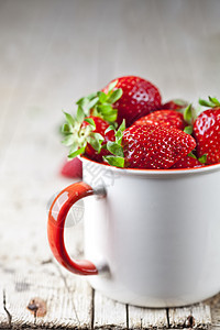 生锈木制木头b上白陶瓷杯中的有机红色红草莓甜点叶子早餐乡村制品水果杯子营养陶瓷浆果图片
