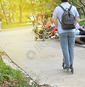 自信的高个高大的男人 在夏天的周末骑着摩托车穿过公园图片