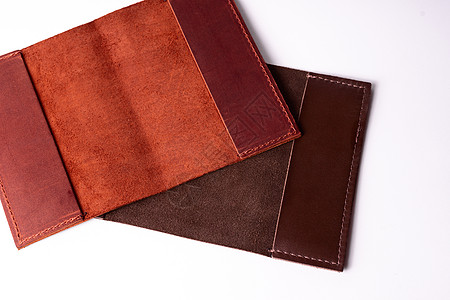 两个手工制作的皮革护照封面隔离在白色背景上 特写视图 封面是红色 棕色和开放的图片