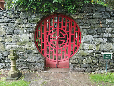 中国花园的红门锁着 不输入符号植物指示牌岩石石头红色藤蔓图片