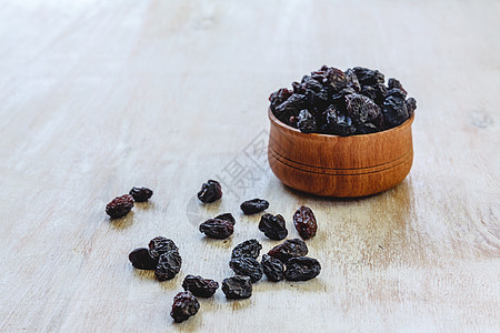黑蓝葡萄干在一个木碗里 在明亮的白色背景上食物宏观维生素饮食甜点脱水营养美食水果团体图片