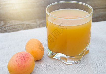 一杯杯中夏季饮料和新鲜果汁 在松尼日户外的餐巾纸上加成熟的杏子图片
