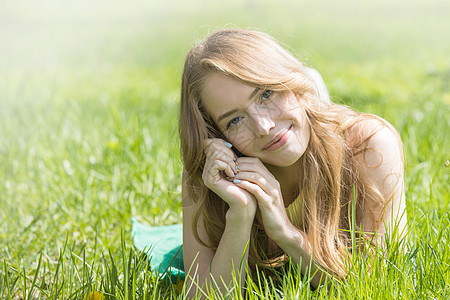女孩躺在草地上快乐女士喜悦金发闲暇自由场地享受公园说谎图片