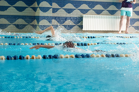 孩子们游自由式泳池 室内游泳池里有清蓝的水团队运动员男生男性竞赛水池孩子蓝色游泳者车道图片