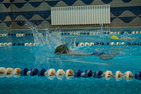 孩子们游自由式泳池 室内游泳池里有清蓝的水孩子中风运动员女性蓝色竞争车道水池竞赛女孩图片