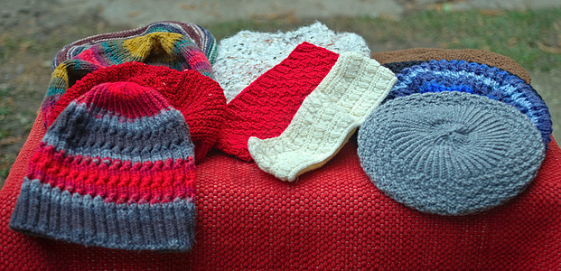 桌子上有许多五颜六色的手工传统冬帽针织品女士外套帽子销售衣服织物配饰羊毛收藏图片