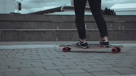 妇女滑板运动员腿在城市的滑板特技骑术坡道女孩行动蓝色成人锻炼滑冰极限图片