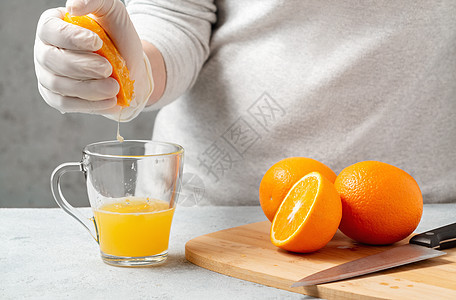 女人把橙汁挤在玻璃杯里营养早餐水果女孩树液女士玻璃女性照片挤压器图片