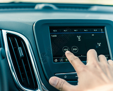 男性用汽车液晶信息屏幕改变无线电台的男子手音乐控制技术手指男人控制板导航收音机调频车站图片