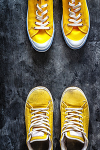 黄黄色旧穿的肮脏破烂运动鞋和新运动鞋纺织品活动衣服蕾丝男人二手跑步女孩运动绳索图片