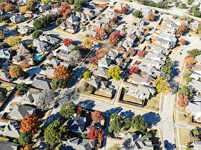 在达拉斯郊区的顶端住宅区 有明亮的秋叶彩色树叶住宅邻里高架房子财产水池抑制花园车库建筑图片
