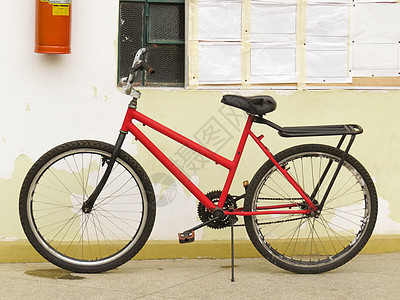旧的 破旧的 废弃的红色自行车靠靠墙倾斜图片
