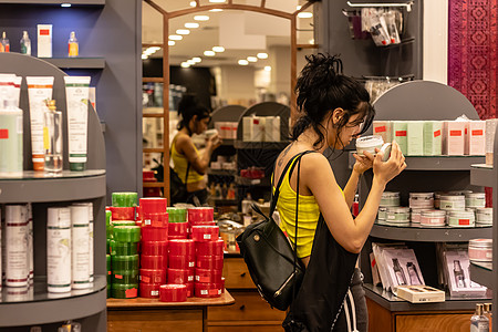 在商店检查化妆品的女女孩图片