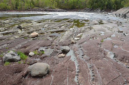 含灰石和红石的河床灰色溪流岩石红色急流地质学图片