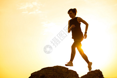 美丽的女赛车手从山路上的岩石跳出来 在热暑假日落 运动和活跃的生活方式保健活动日落农村卫生女孩赛跑者闲暇跑步慢跑图片