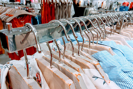 衣服挂在设计师服装店的架子上商业衣柜织物店铺裙子收藏衬衫女性展示服装图片