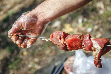 男人在切肉机上绑肉 缝近一点烧烤美食细绳猪肉营养盘子牛肉野餐木炭烹饪图片