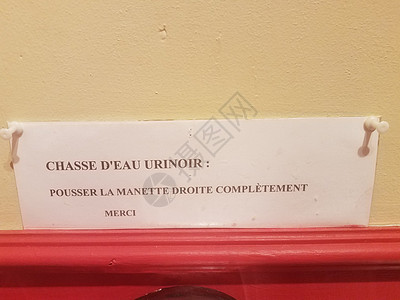 将把手推向右侧冲上小便池 用法语谢谢您完全地卫生间潮红指示牌背景图片