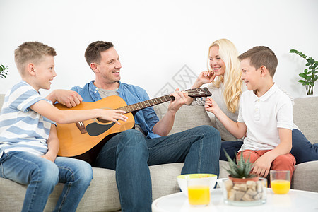 欢乐的caucaosian家庭微笑 在舒适的现代家一起弹吉他和唱歌乐器男人父亲闲暇幸福孩子们客厅歌曲爸爸活动图片