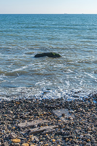 海岸的海洋中孤独石块海滩波浪石头蓝色海潮悬崖季节太阳岩石乡村图片