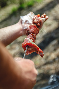 男人在切肉机上绑肉 缝近一点营养香料野餐派对火焰木炭烧伤细绳美食盘子图片