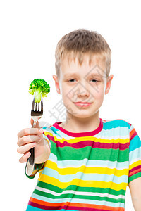 一个男孩的垂直肖像 花椰菜在叉子上 蔬菜图片