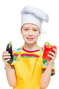 带着胡椒和蛋卷的厨帽中儿童垂直肖像图片