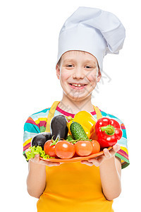男孩用帽子做饭 配有一盘成份     健康的蔬菜图片