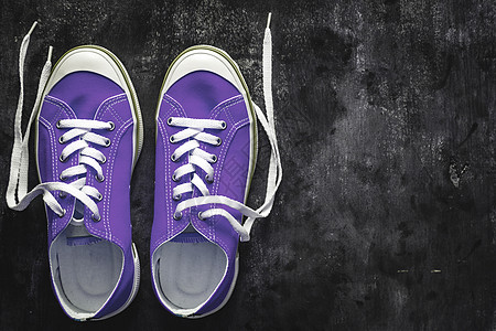 紫色粉红色淡紫色运动鞋 在深色混凝土背景上系有解开的鞋带 复制空间 从上面看活动时尚蓝色生活女性旅行运动潮人青年帆布图片
