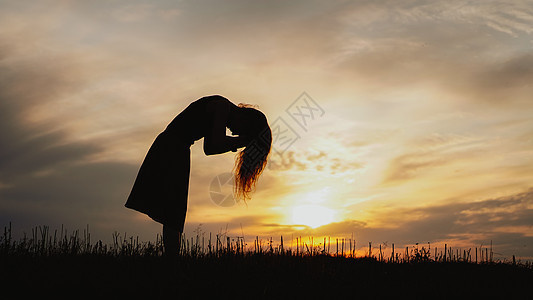 日落时站在干草地上的年轻女子的休眠女士头发地平线金子崇拜自由喜悦幸福成人天空图片