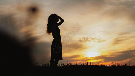 日落时站在干草地上的年轻女子的休眠女性阳光女孩自由太阳成人崇拜金子空气女士图片