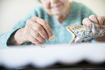 无法辨认的老年妇女在支付帐单后从钱包中的养老金中抽取剩余硬币 他们手握这些硬币的详细特写照片数数女士金融女性生存账单贫困现金商业图片