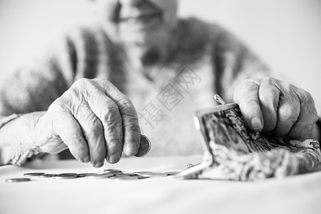 无法辨认的老年妇女在支付帐单后手拿钱包中养老金中的剩余硬币计数 黑白图象成人现金商业贫困生存数数女士退休女性金融图片