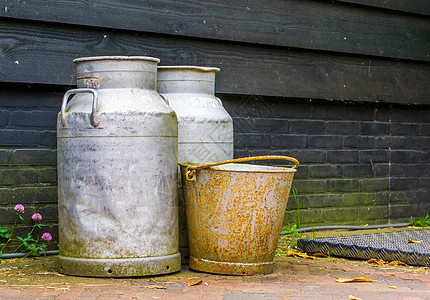 农业背景 传统农场设备 金属奶罐和一个老生锈桶子图片