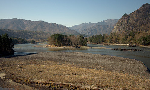 河流泉水的河岸被洪水淹没 海峡中央有一个岛屿环绕着山峰包围图片