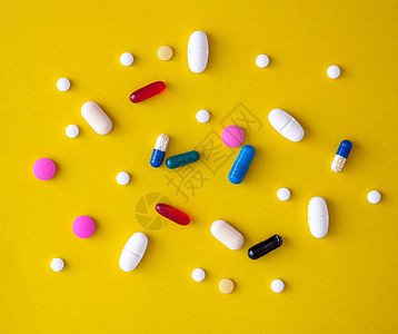 以黄色为背景的分散式多种多色药片 从上面查看 特写 Y药物化学品治愈药剂药理制药预防卫生药片科学图片