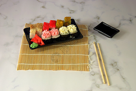 竹餐巾上的一套寿司 旁边是筷子和酱油的杯子图片