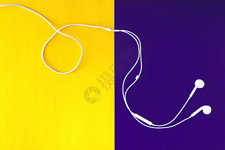 黄紫色背景上的白色耳机 从上面看小路娱乐工具艺术电话耳朵纸板音乐立体声技术图片
