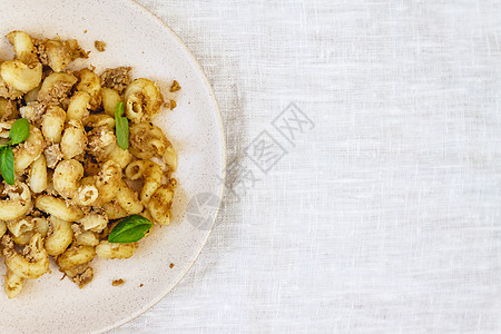 传统的苏联俄罗斯面食 粉丝 海军面食 在浅色织物背景的白盘上放着肉 从上面的极简主义视图牛肉国家洋葱美食食物香料胡椒盘子面条桌子图片