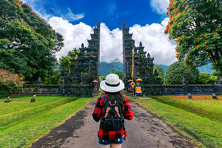 背着背包在印度尼西亚巴厘大门口行走的女旅行者图片