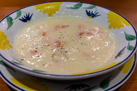 在一个碗里摇盘黄色液体蔬菜勺子白色浓汤奶油饮食盘子午餐图片